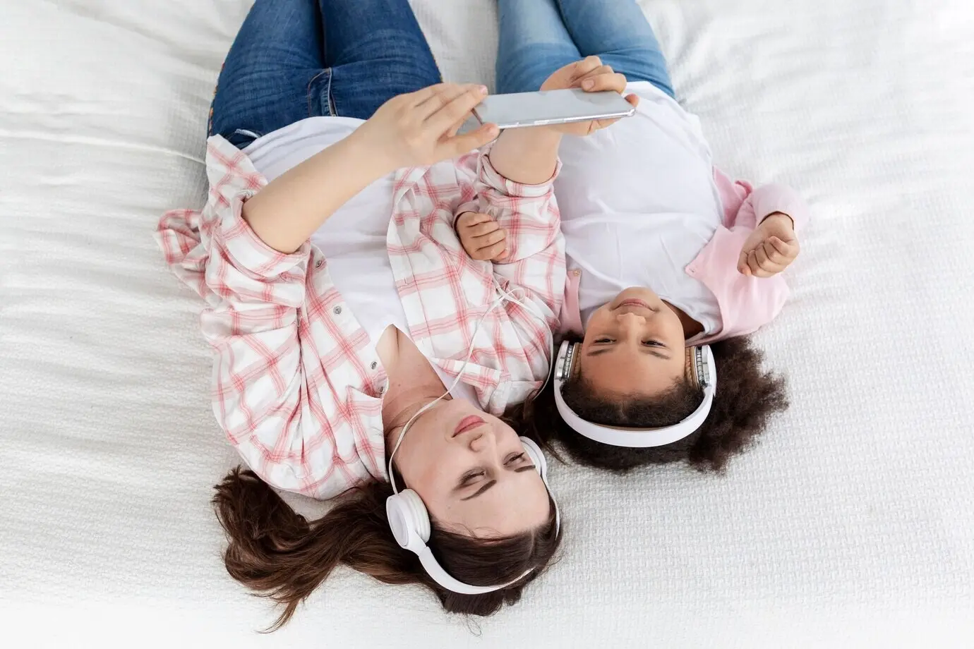 Вид сверху на мать и дочь, слушающих музыку.